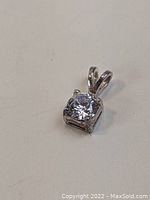 Front view of the sterling silver pendant with clear stone showing faceted round stone in square setting.