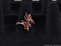 Photo of the sterling silver cocktail ring on a black velvet display stand, showing the orange marquise-cut stones in a leaf pattern.