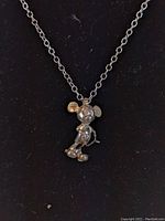 Front view of sterling silver Mickey Mouse pendant on chain showing details of pendant design and chain links.