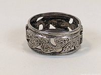 Side angled view of sterling silver Art Nouveau open work band ring showing leaf motifs and open cutouts