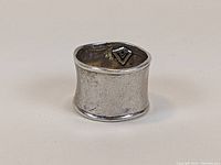 Sterling silver wide band ring with visible hand-wrought texture and hallmark inside.