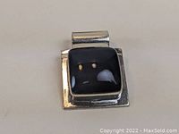 Front view of Taxco Mexican sterling silver pendant with black onyx stone set in square bezel on a flat silver base.