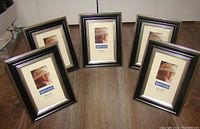 Five black and gold wooden picture frames arranged on floor, all sized 4x6 inches with Pinnacle branding visible on photo inserts.