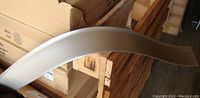 Curved L-shaped wall base profile extruded from box showing smooth face and toe bead in sterling silver.