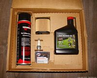 Top view of the Craftsman tune-up kit contents showing oil, air filter, spark plug, and lubricant spray in the box
