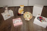 Group photo of all cat-themed items showing salt and pepper shakers, figurines, ring tray, photo frame, and ornament with original packaging.