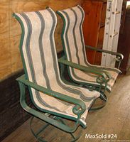 Pair of hunter green metal swivel rocking chairs with fabric striped upholstery, seen from side at angle, showing armrests and swivel base.