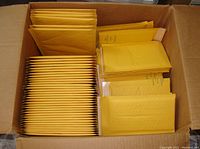 Overhead view of a box filled with different sized kraft bubble mailers organized inside showing quantity and organization.