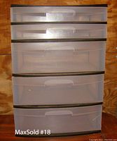 Front view of the Sterilite 5-drawer storage tower displaying the five semi-transparent clear drawers with built-in handles against a black frame.