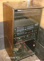 Full view of the Kenwood stereo system in wooden cabinet with smoked glass front showing stacked components.