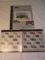 Photo showing the double wide sheet with 25 detailed colorful Historic Land Vehicle stamps and part of the original folder featuring images of vintage vehicles and collection years.