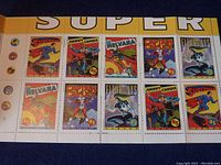 Photo of 10 unused superhero stamps in original booklet, showing vibrant comic art stamps including Superman and others.