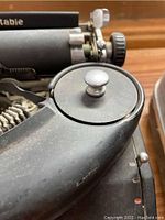 Close-up of the typewriter's platen knob and part of the body showing wear and dust.