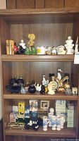 Full shelf view showing a variety of Avon collectible bottles and boxed items with diverse shapes, colors, and materials.