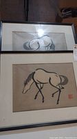 Two framed Chinese brush paintings of horses stacked one above the other, whole lot view showing size and framing