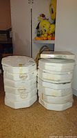 Four stacks of styrofoam packaging holding fourteen collectible plates