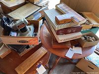 Overview photo of games including cribbage board, backgammon, and other boxed games on a wooden table, plus rock collection box.