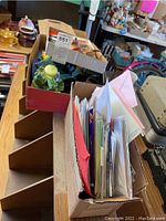 Photo shows assorted greeting cards organized in a box with various colors and designs visible.