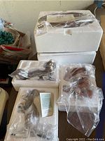 Four boxed Lenox animal sculptures including African Elephant Family in original styrofoam packaging and plastic wrap.