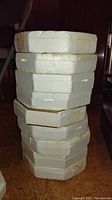 Stack of white foam packaging boxes containing the plates