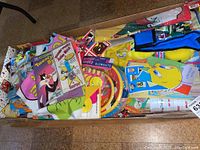 Open box showing a variety of colorful Looney Tunes character-themed items, including plates, bags, and puppets.