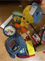 Full lot showing Tweety Bird large light-up figure, wall clock, and several bags with Tweety Bird graphics. Posters rolled up next to bags.