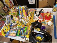 Overview of the lot arranged on a table showing various Tweety and Looney Tunes collectibles including puzzles, toys, keychains, and buttons.