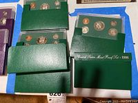 Top view of all six proof coin sets in green folders arranged on a table, showing sets from 1994, 1995, and 1996 in original mint packaging.