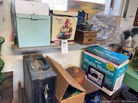 Top shelf and windowsill items including boxed sewing machine, wooden coffee grinder, wood container, and more.