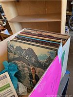 Box of over 20 vinyl LP records with RCA Victor album cover visible featuring a man in a mountain setting.