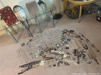 Wide view of assorted jewelry laid out including necklaces, brooches, earrings, bracelets.