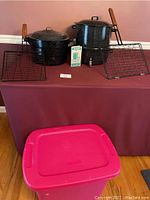 Full lot showing seafood pot with lid, base, two BBQ racks, and pink bin