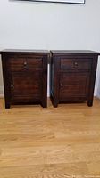 Two dark wood nightstands side by side on wooden floor.