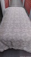 Full view of queen size comforter showing grey color and diamond geometric pattern