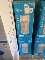 Photo of boxes stacked showing Blueair Blue PURE 411+ branding and air purifier image on packaging.