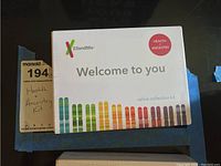 Front view of the sealed 23andMe Health + Ancestry kit box showing colorful chromosome graphics and 'Welcome to you' text