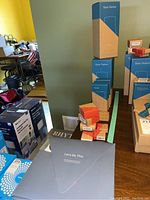 Photo of stacked boxed base stations and other system components on a table.