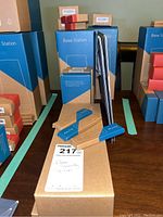 Multiple base stations in original blue and brown packaging, along with several small boxed components and key fobs.