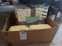 Box containing two packaged items: a Sleep Artisan adjustable pillow loft and an Aden+Anais muslin blanket with star and stripe designs.