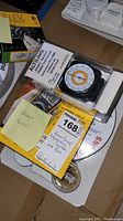 Photo showing Altilinq altimeter and barometer device in package and Fluke voltage tester in box with stickers.