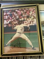 Framed Blue Jays signed photo of a pitcher mid-throw in uniform with autograph