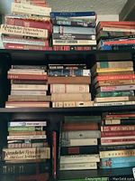 Bookshelves stocked with a variety of classic literature and art books, some titles visible include 'Hemingway', 'Wormhole', and 'Obituaries'.