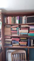 Wide view of bookshelves filled with books including poetry and classic collections.