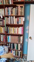 Bookshelves filled with assorted used books varying in size and color, showing wear on bindings and covers.