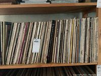 Shelf holding approximately 40 vinyl record albums showing varied spines including "The Smithsonian Collection of Classic Jazz"