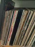 Side view of approximately half the vinyl record albums showing varied colors and text on album spines, mostly classical and jazz.