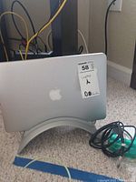 MacBook Pro placed vertically in stand with cables on floor