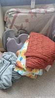 Three throw blankets stacked with the gray lap tray and wedge pillow visible in the lot.