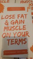 Close-up of the book cover 'Lose Fat & Gain Muscle On Your Terms' by Richa Prasad and Lucy Liang.