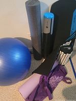 Photo showing various pieces of exercise equipment including foam rollers, balance board, and stability ball.